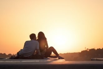 couple sitting near trees during golden hour