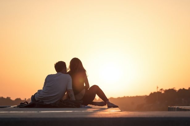 couple sitting near trees during golden hour